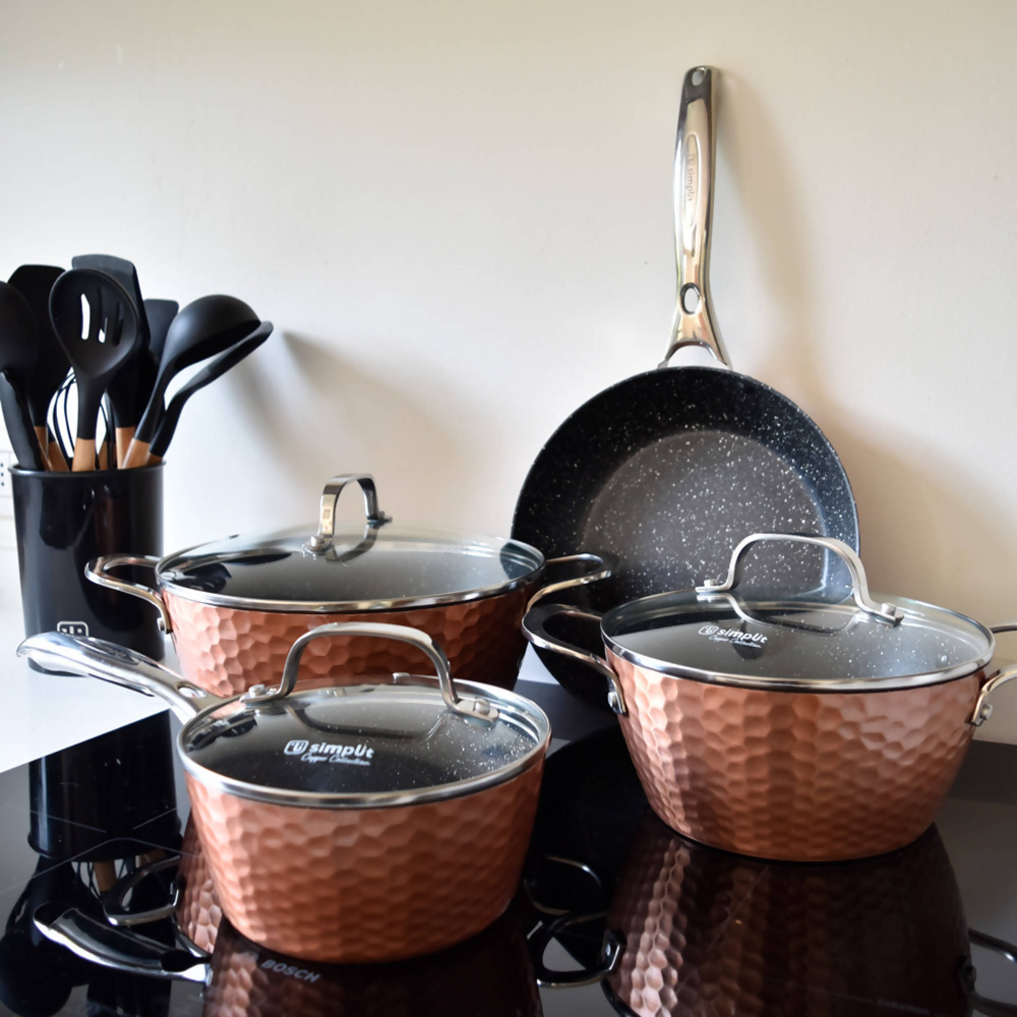 Estantes de cocina con sartenes de cobre, ollas y otros utensilios